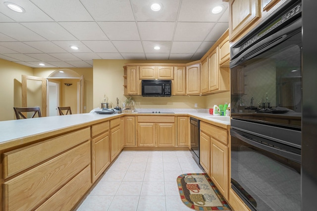 kitchen with light brown cabinets, kitchen peninsula, a paneled ceiling, light tile patterned floors, and black appliances