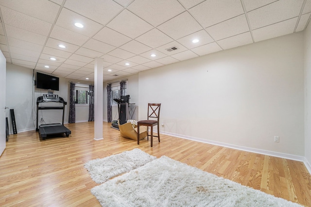 workout area featuring a paneled ceiling and wood-type flooring