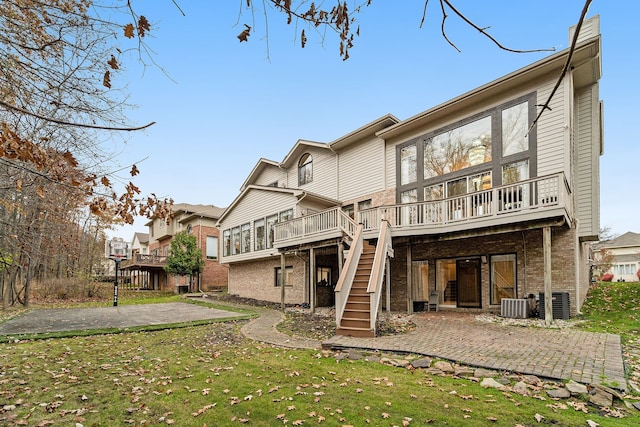 back of property featuring cooling unit, a yard, a patio, and a wooden deck