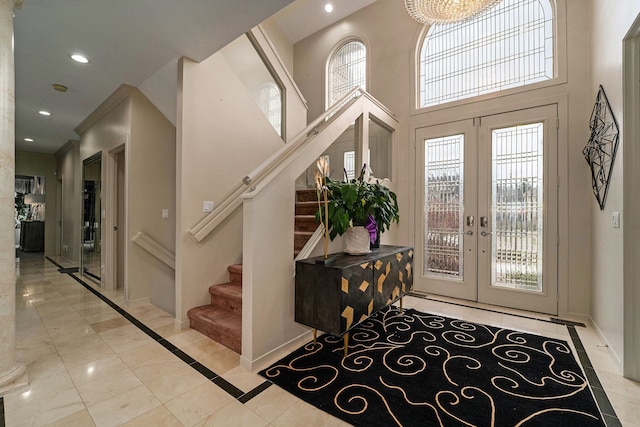 entryway featuring a wealth of natural light, french doors, a high ceiling, and a notable chandelier