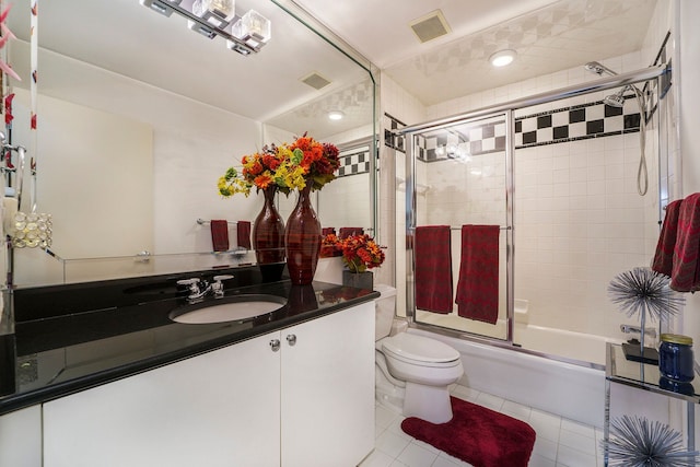 full bathroom with shower / bath combination with glass door, tile patterned flooring, vanity, and toilet