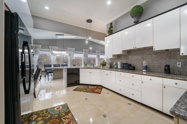 kitchen with tasteful backsplash, black appliances, white cabinetry, hanging light fixtures, and lofted ceiling