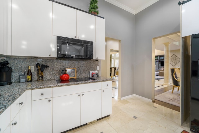 kitchen with black appliances, dark stone countertops, white cabinetry, and ornamental molding