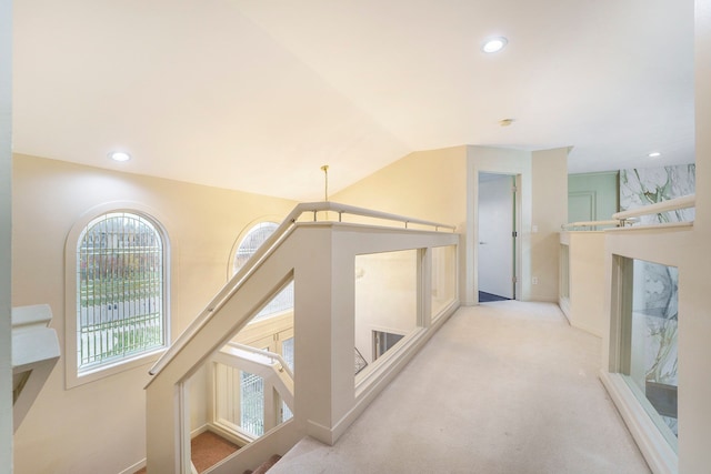 corridor with light carpet and lofted ceiling