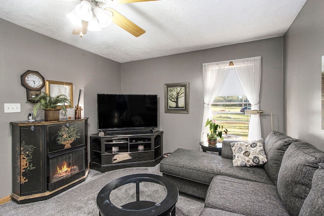 carpeted living room with a textured ceiling and ceiling fan