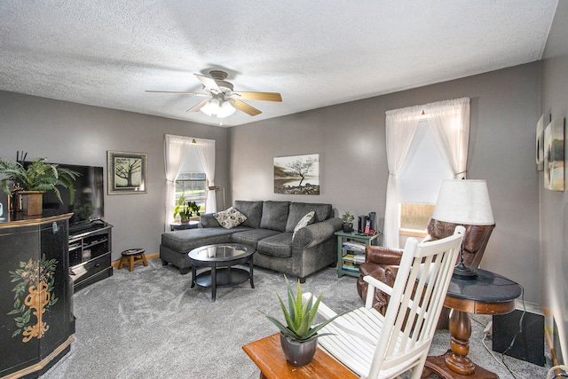 carpeted living room with ceiling fan and a textured ceiling