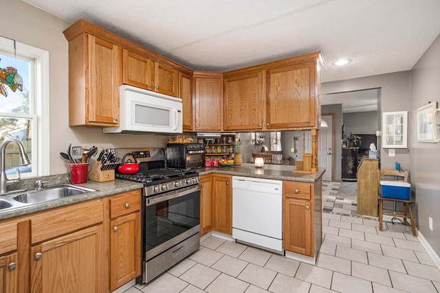 kitchen with kitchen peninsula, sink, and white appliances