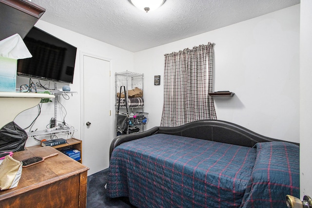 bedroom featuring carpet flooring and a textured ceiling