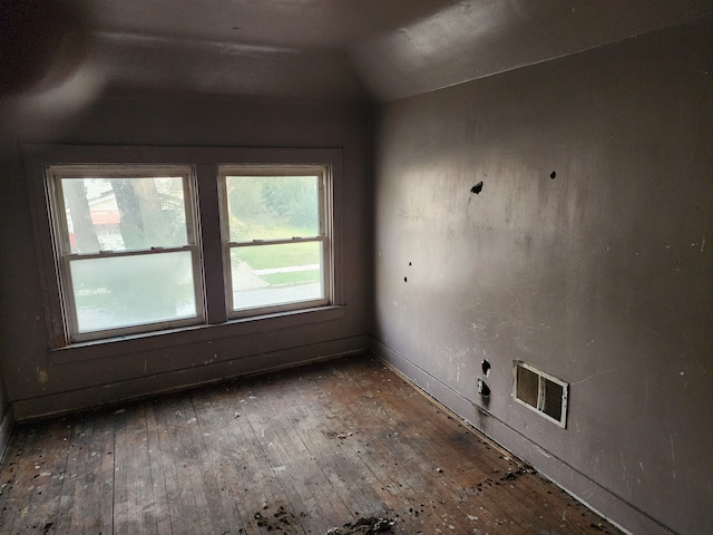 unfurnished room with hardwood / wood-style floors and lofted ceiling