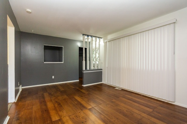 unfurnished room with dark hardwood / wood-style flooring