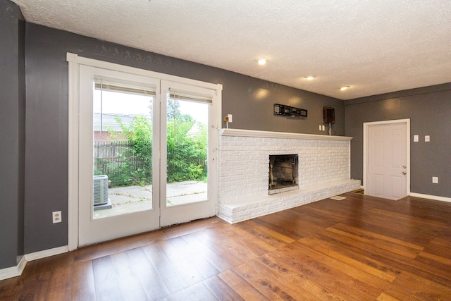 doorway to outside with a fireplace, a textured ceiling, and hardwood / wood-style flooring