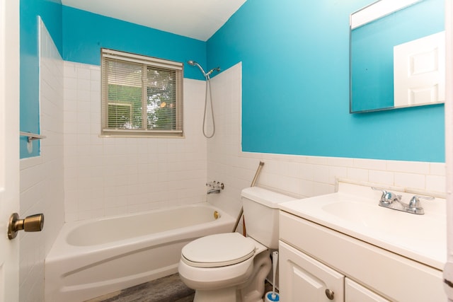 full bathroom featuring toilet, vanity, tile walls, and tiled shower / bath