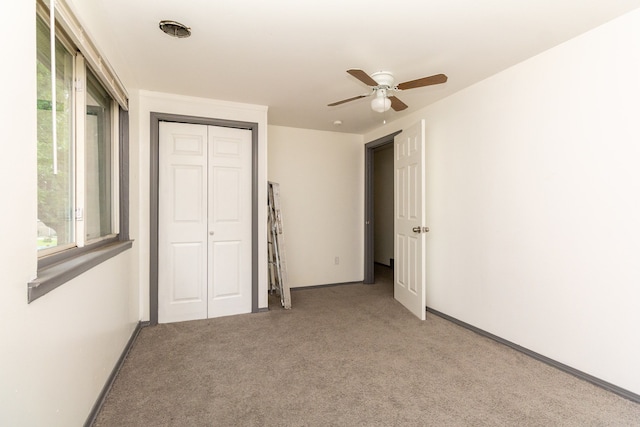 unfurnished bedroom with ceiling fan, a closet, and light colored carpet