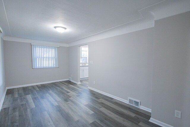 unfurnished room with dark hardwood / wood-style flooring