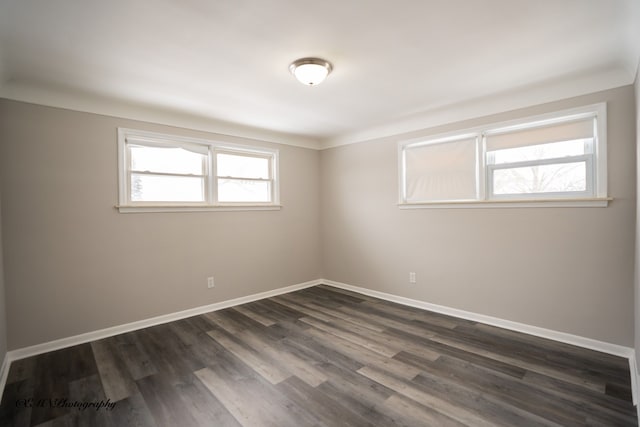 spare room with dark wood-type flooring and baseboards