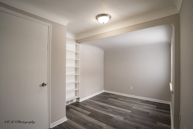 interior space featuring dark wood-style flooring and baseboards