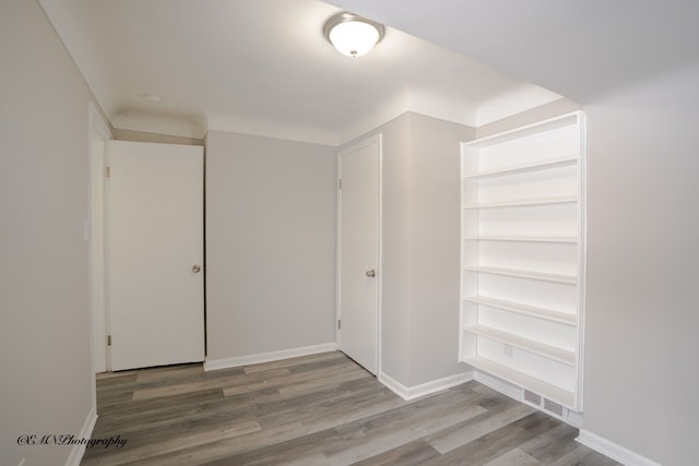 interior space featuring wood finished floors, visible vents, and baseboards