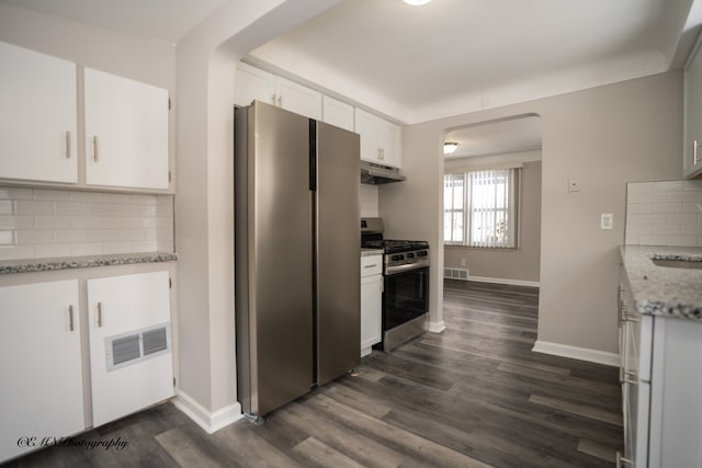 kitchen with dark wood-style floors, tasteful backsplash, appliances with stainless steel finishes, white cabinets, and under cabinet range hood