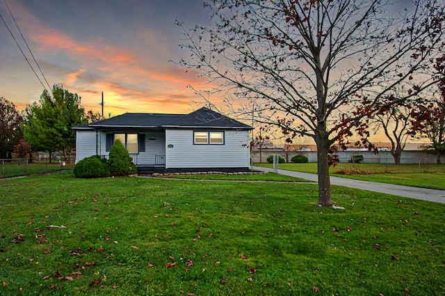 view of front of home with fence and a front lawn