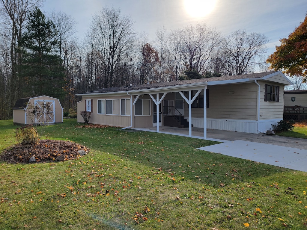 back of property with a lawn and a storage shed