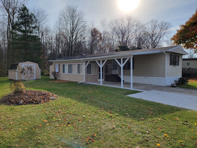 back of property with a lawn and a storage shed