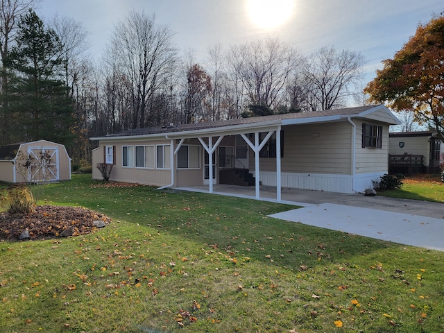 view of front facade featuring a front yard, a shed, and a carport