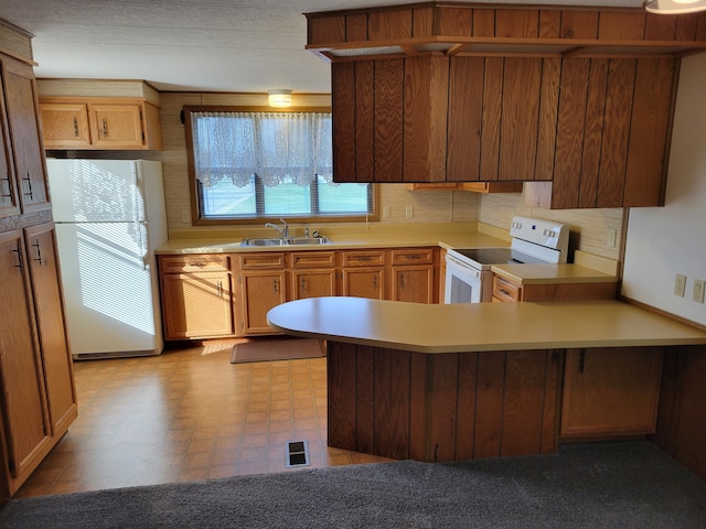 kitchen with tasteful backsplash, kitchen peninsula, sink, and white appliances