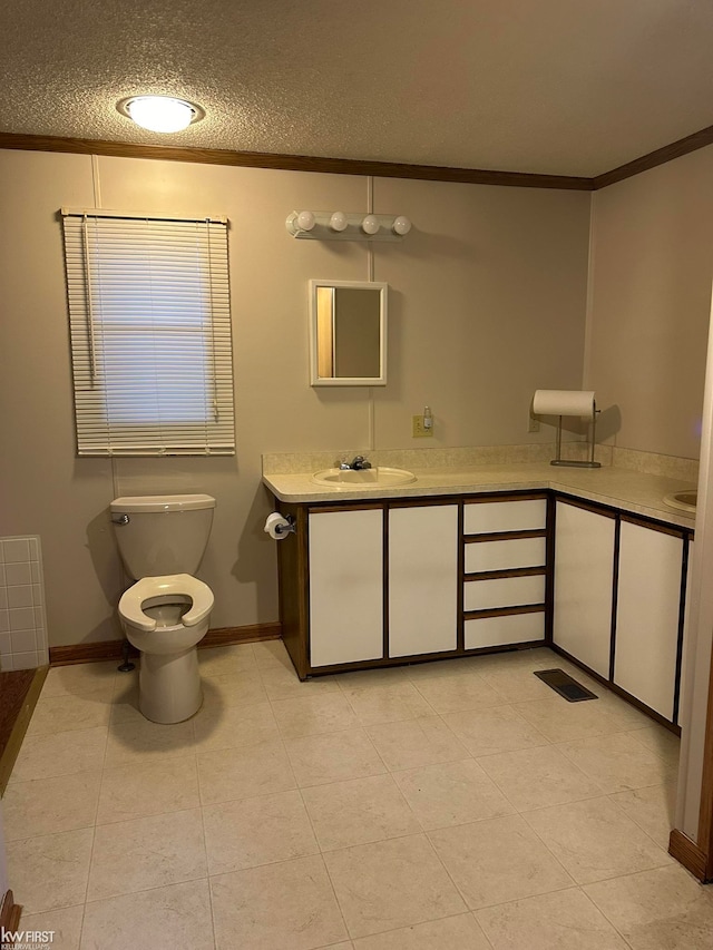 bathroom featuring vanity, crown molding, tile patterned flooring, toilet, and a textured ceiling