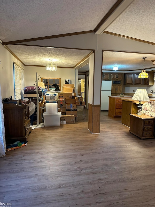 interior space featuring lofted ceiling with beams, crown molding, a textured ceiling, and light hardwood / wood-style flooring