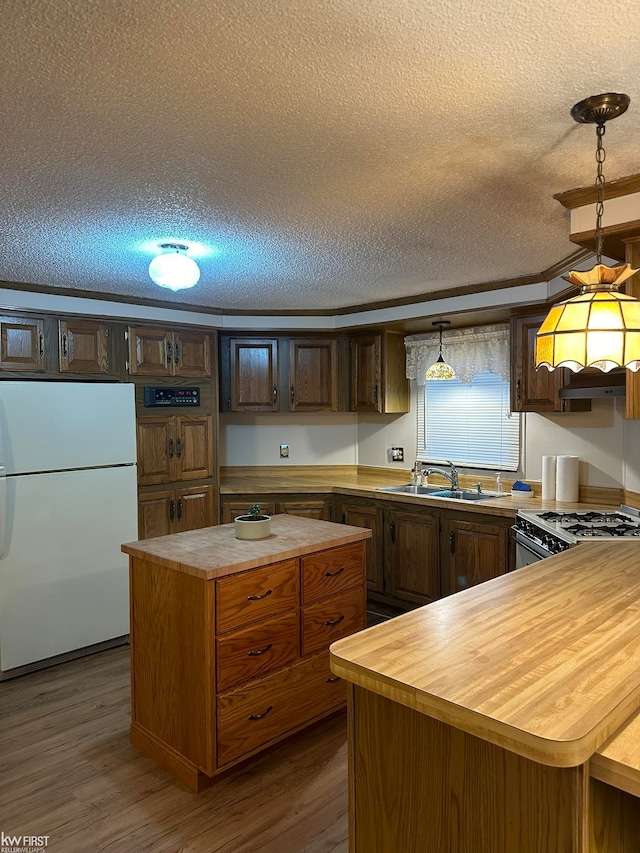 kitchen featuring dark hardwood / wood-style floors, a center island, white appliances, and sink