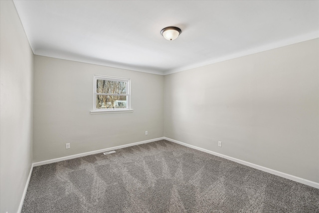 empty room featuring carpet and baseboards