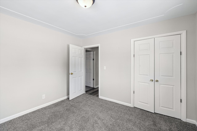 unfurnished bedroom featuring carpet floors, a closet, and baseboards