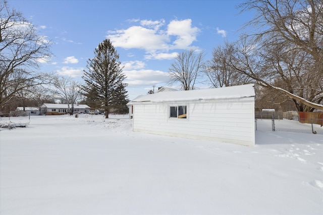 snow covered structure featuring fence