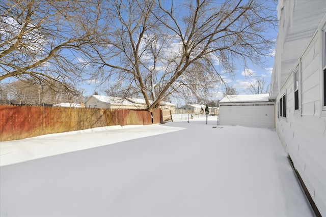 yard covered in snow with fence