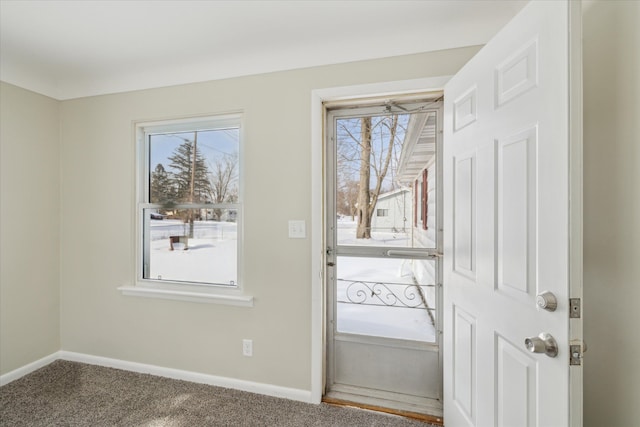 doorway to outside with carpet flooring, plenty of natural light, and baseboards