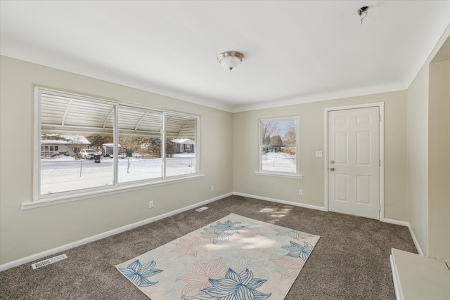 unfurnished room featuring visible vents, dark carpet, and baseboards