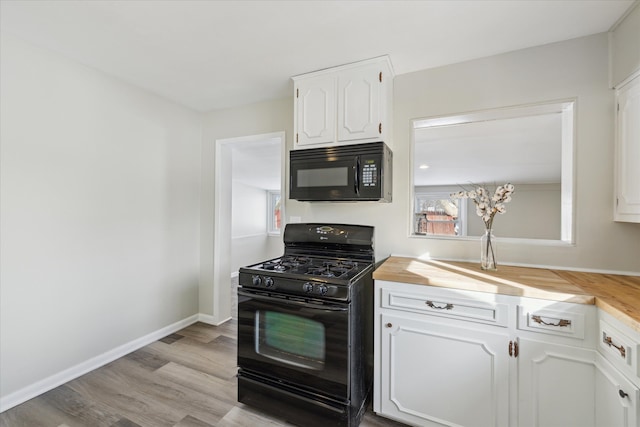 kitchen featuring light wood-style floors, white cabinetry, black appliances, wood counters, and baseboards