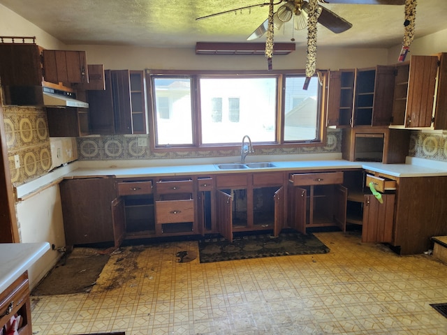 kitchen with backsplash, ceiling fan, sink, and a textured ceiling