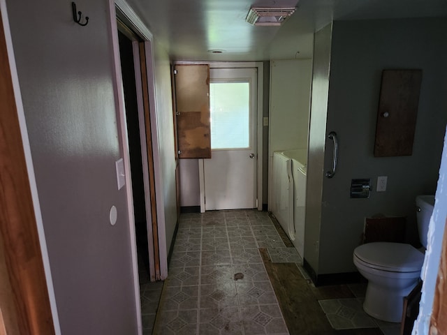 bathroom with separate washer and dryer, tile patterned flooring, and toilet