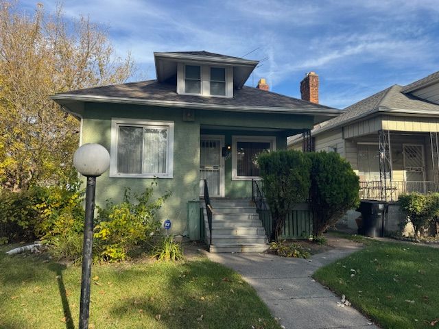 bungalow featuring a front lawn