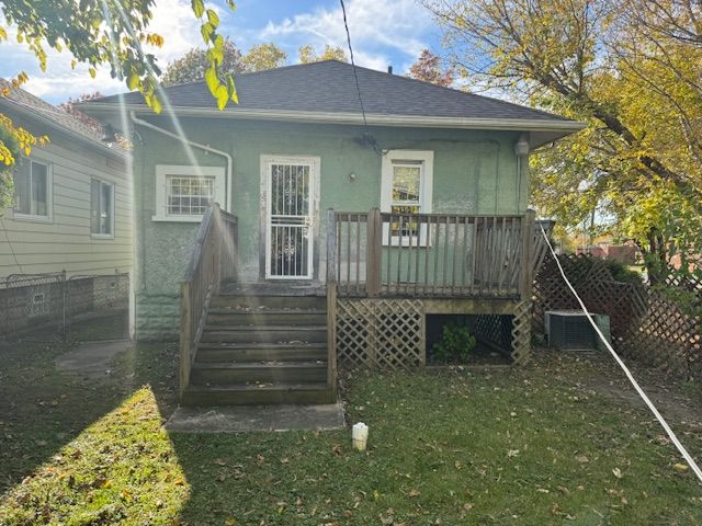 back of house with a wooden deck, a yard, and central AC