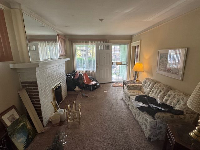 carpeted living room featuring a brick fireplace