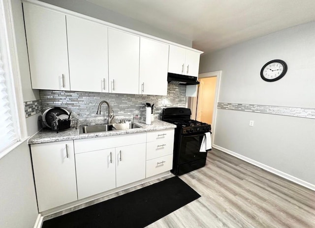 kitchen with sink, black gas range, tasteful backsplash, light hardwood / wood-style floors, and white cabinets