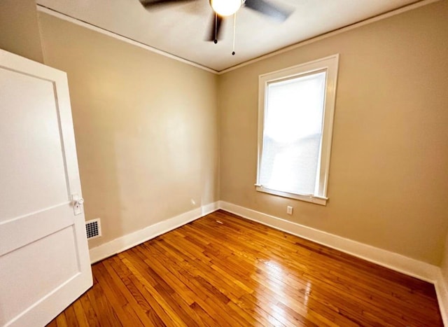 empty room with wood-type flooring, ornamental molding, and ceiling fan