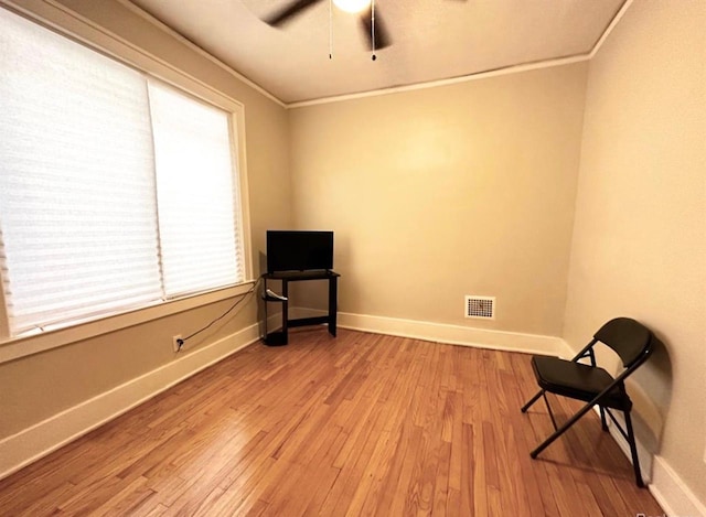 unfurnished room with crown molding, ceiling fan, and light hardwood / wood-style flooring