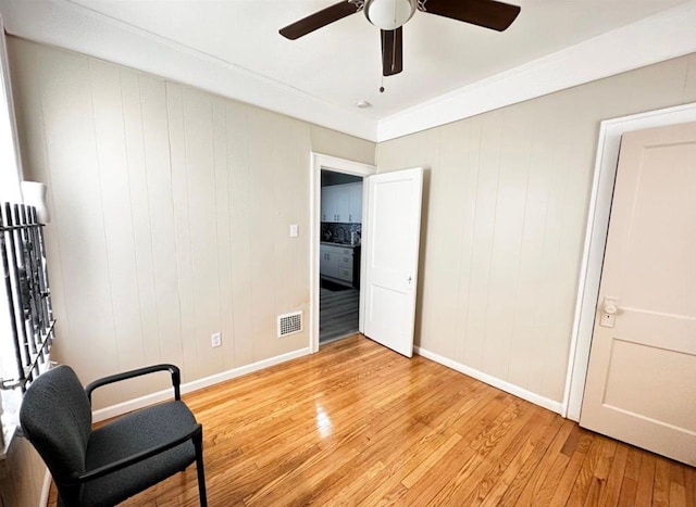 living area with ceiling fan and light hardwood / wood-style floors