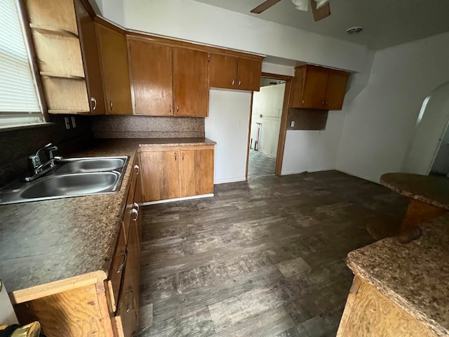 kitchen featuring decorative backsplash, ceiling fan, sink, and dark wood-type flooring