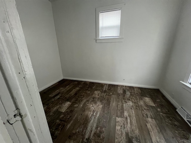 empty room with dark hardwood / wood-style flooring