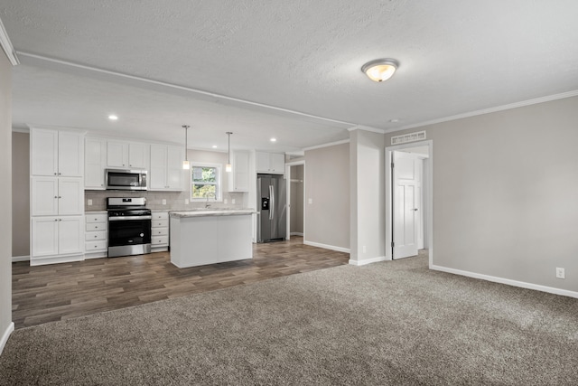 kitchen with decorative light fixtures, a kitchen island, white cabinetry, and stainless steel appliances