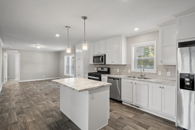 kitchen featuring a center island, stainless steel appliances, white cabinetry, and sink